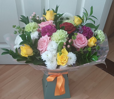 Letty’s arrangement of yellow and pink roses, white flowers and mixed foliage