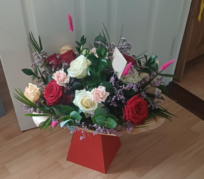 Radiant Romance Bouquet - A beautifully handcrafted arrangement designed to brighten any space with timeless elegance. This bouquet blends classic red and ivory roses with soft blush carnations, surrounded by lush greenery and delicate lilac fillers for a graceful, textured finish. Accented with touches of vibrant pink plume stems, it creates a stunning balance of romance, freshness, and modern charm.

Presented in a stylish red display box, this arrangement is perfect for birthdays, anniversaries, thank-yous, or simply to make someone’s day a little more beautiful.

Each bouquet is carefully arranged for maximum freshness and delivered ready to admire, no vase needed.