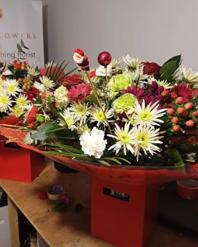 Festive Starburst - A colourful Christmas flower bouquet with red and white blooms, seasonal flowers, greenery and festive decorations. Bright and cheerful.