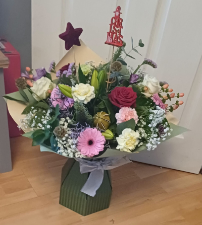 Christmas Wishes - A pastel Christmas flower bouquet with roses, gerberas, seasonal blooms and festive decorations. Soft, elegant and festive.