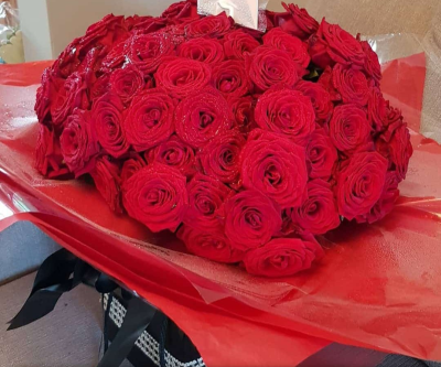 Centennial Red - A luxurious hand-tied bouquet of 100 premium red roses, expertly arranged to create a bold, romantic statement for unforgettable moments.
